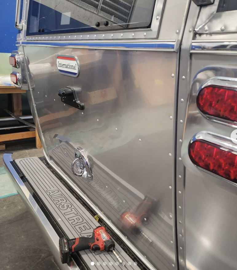 Riveted aluminum side panel on an Airstream International with a drill on the step