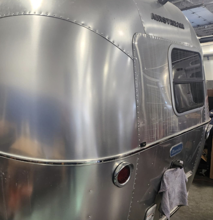 Polished rear of an Airstream Bambi showing riveted aluminum panels